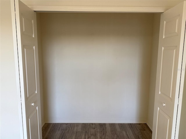 empty room featuring dark wood-type flooring and baseboards