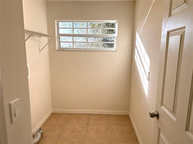 walk in closet with light tile patterned floors