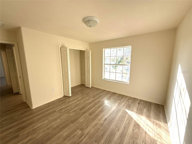 unfurnished bedroom featuring baseboards and wood finished floors