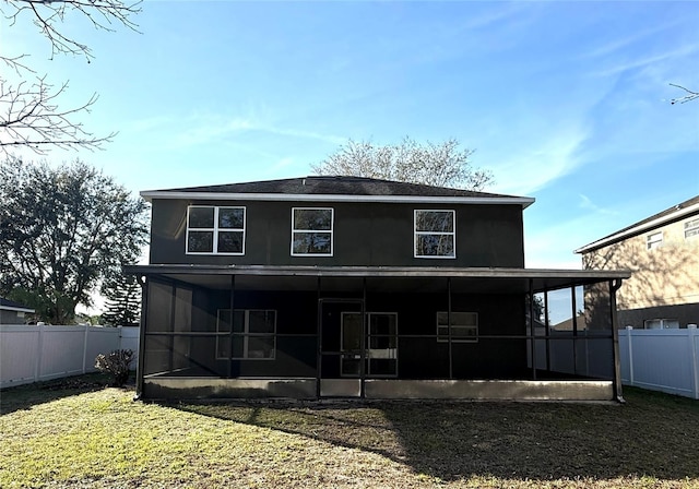 rear view of property with a lawn, a fenced backyard, and a sunroom