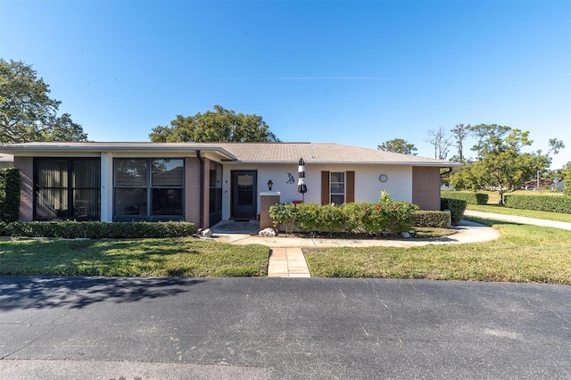 ranch-style home with a front lawn