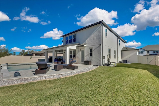 back of property with a lawn, an outdoor living space, a patio, and central AC