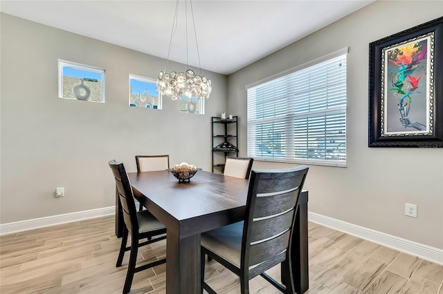 dining area with light hardwood / wood-style floors and an inviting chandelier