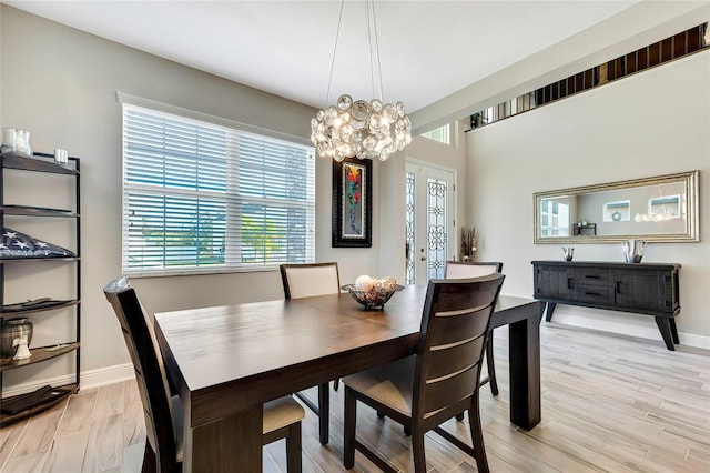 dining area featuring light hardwood / wood-style floors, an inviting chandelier, and a healthy amount of sunlight