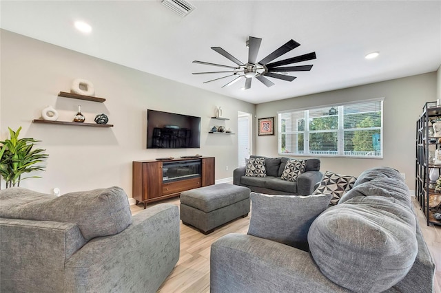 living room with ceiling fan and light hardwood / wood-style flooring