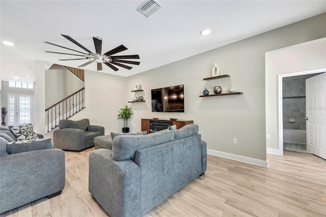 living room featuring ceiling fan and light hardwood / wood-style flooring