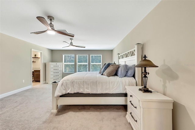 bedroom featuring connected bathroom, light colored carpet, and ceiling fan