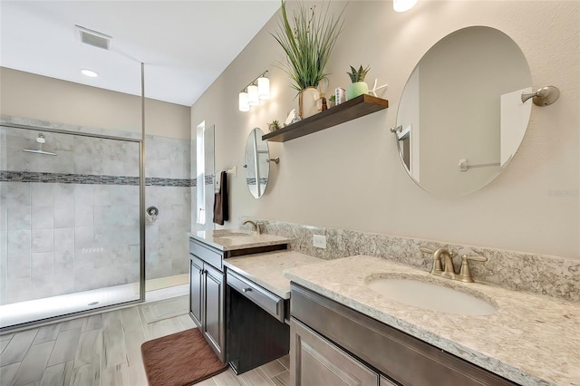 bathroom featuring hardwood / wood-style floors, vanity, and tiled shower