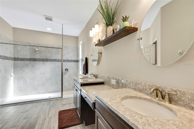 bathroom featuring hardwood / wood-style flooring, vanity, and tiled shower