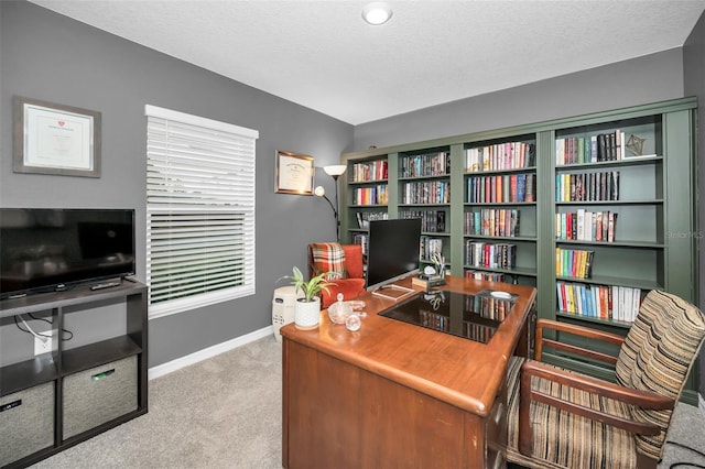 carpeted home office featuring a textured ceiling