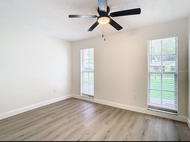 unfurnished room with ceiling fan, light hardwood / wood-style floors, and a textured ceiling