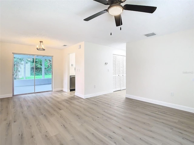 unfurnished living room with light hardwood / wood-style flooring and ceiling fan with notable chandelier