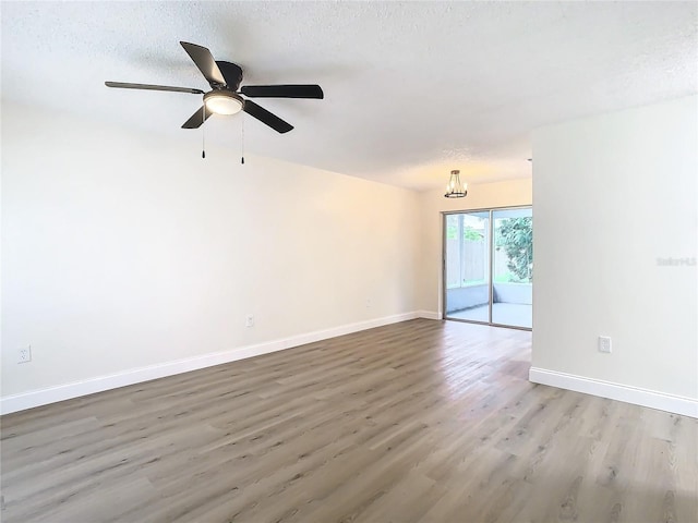 spare room featuring ceiling fan, wood-type flooring, and a textured ceiling