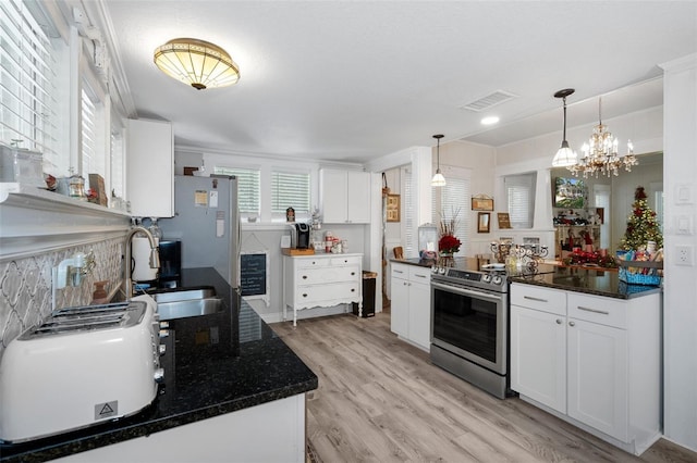 kitchen with white cabinets, decorative light fixtures, stainless steel range with electric stovetop, and sink