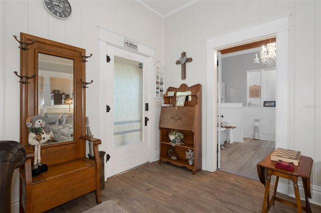 hall with a chandelier, crown molding, and dark wood-type flooring