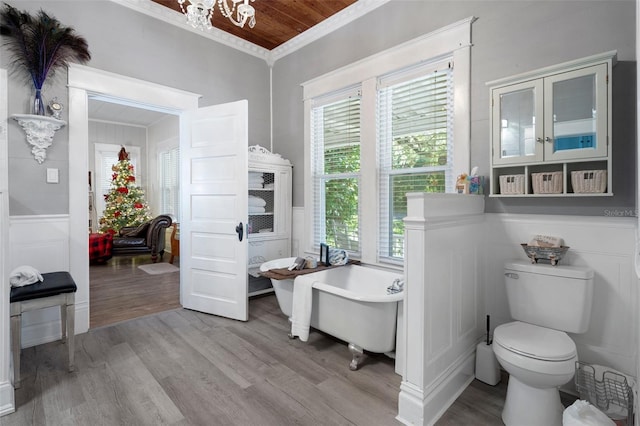 bathroom with a bathing tub, a wealth of natural light, toilet, and hardwood / wood-style flooring