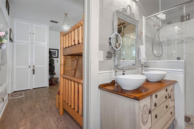 bathroom with hardwood / wood-style floors, vanity, and walk in shower