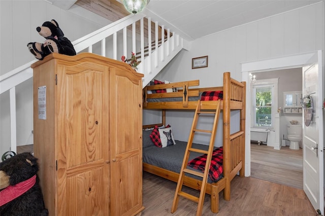 bedroom featuring wood walls and light hardwood / wood-style floors