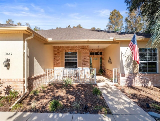 view of exterior entry featuring a carport and a porch