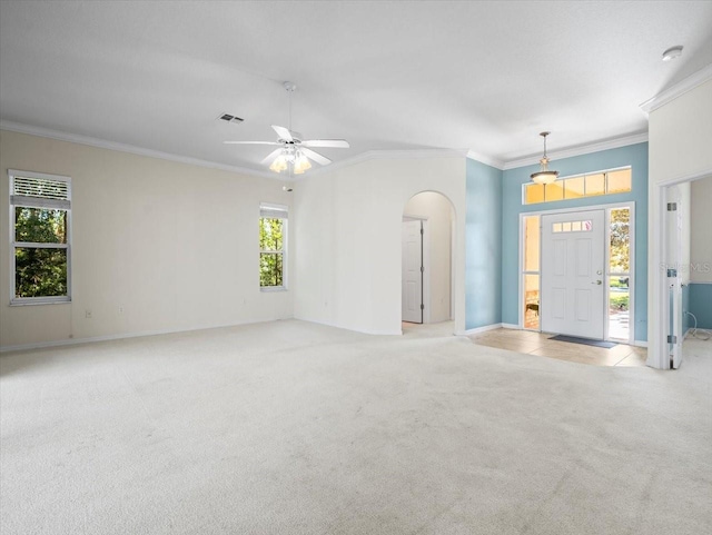 carpeted spare room with a wealth of natural light, ornamental molding, and ceiling fan