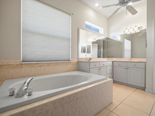 bathroom featuring vanity, a relaxing tiled tub, tile patterned floors, and ceiling fan