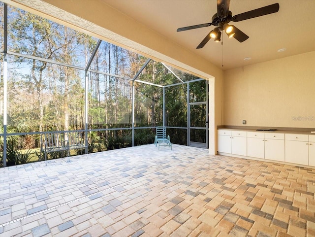 view of patio featuring ceiling fan and a lanai