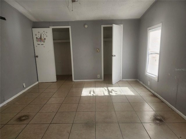 unfurnished bedroom with light tile patterned floors and a textured ceiling