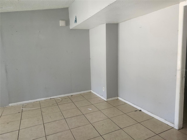 unfurnished room featuring light tile patterned floors and a textured ceiling