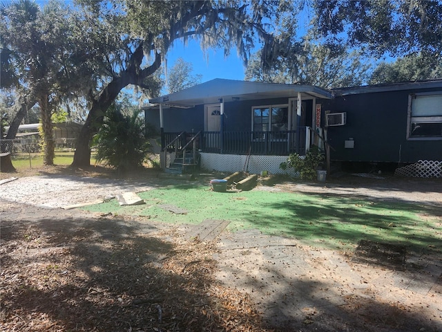 back of property featuring a yard and a wall unit AC