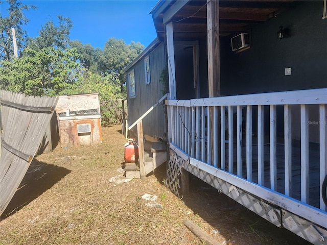 view of yard featuring a wall mounted air conditioner and an outdoor structure