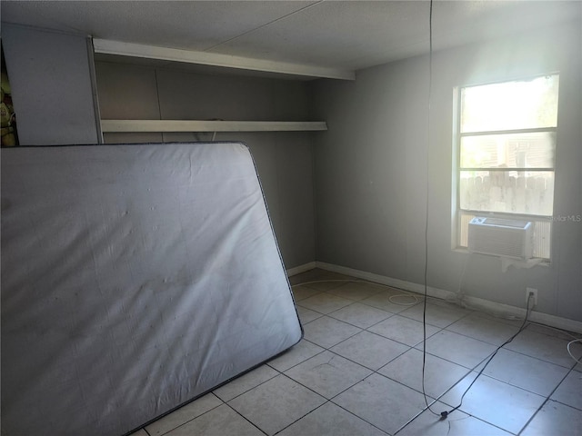 unfurnished bedroom featuring cooling unit and light tile patterned floors