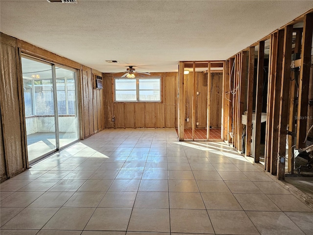 tiled spare room with ceiling fan and a textured ceiling