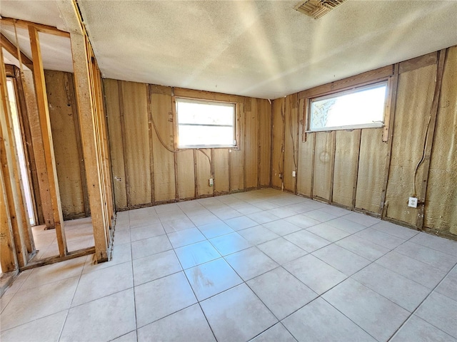 spare room featuring a textured ceiling and plenty of natural light