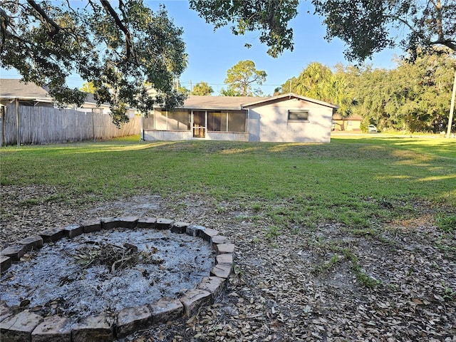 back of house with a sunroom, a fire pit, and a yard