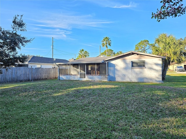 back of property with a yard and a sunroom