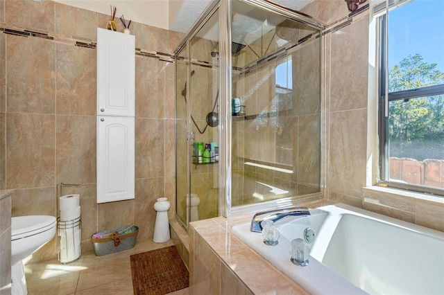 bathroom featuring tile patterned floors, plus walk in shower, tile walls, and toilet