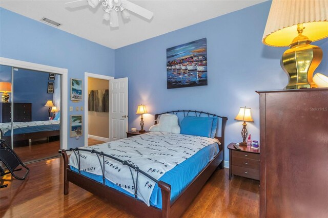 bedroom with a closet, ceiling fan, and dark wood-type flooring