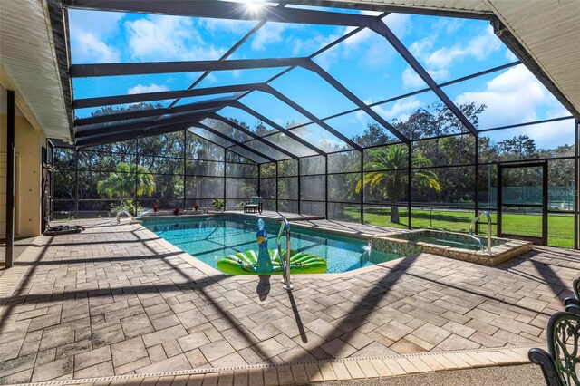 view of swimming pool featuring an in ground hot tub, a patio, and glass enclosure