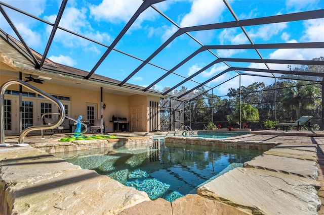 view of swimming pool with glass enclosure, grilling area, french doors, ceiling fan, and a patio