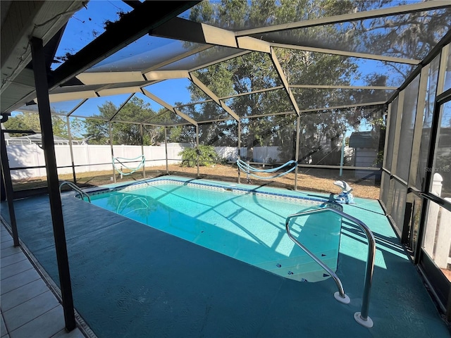 view of pool with glass enclosure and a patio area