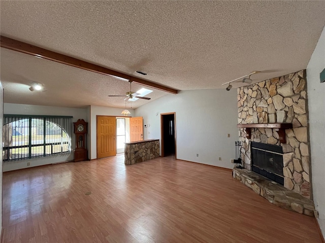 unfurnished living room with a fireplace, a textured ceiling, and hardwood / wood-style flooring