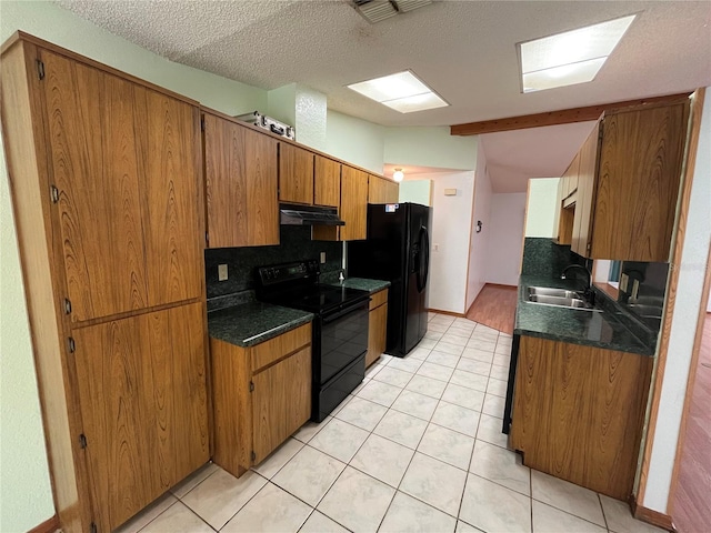 kitchen with decorative backsplash, a textured ceiling, sink, and black appliances