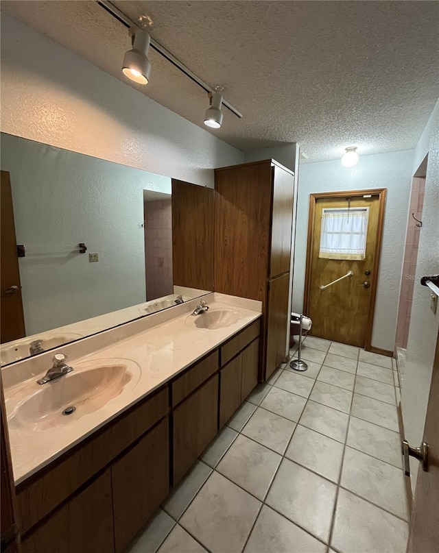 bathroom with rail lighting, tile patterned floors, a textured ceiling, toilet, and vanity