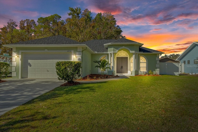 view of front of home featuring a garage and a yard