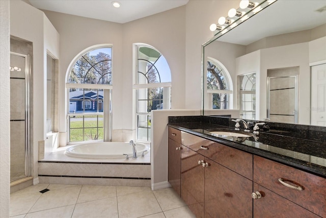 bathroom with tile patterned floors, vanity, and shower with separate bathtub