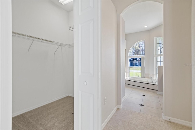 walk in closet featuring light colored carpet