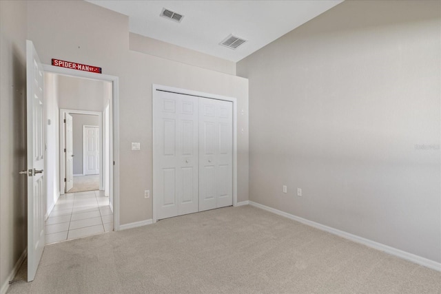 unfurnished bedroom with a closet and light colored carpet