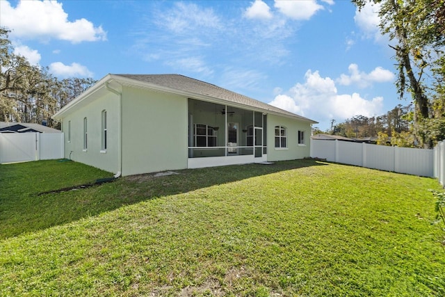 rear view of house featuring a sunroom and a yard