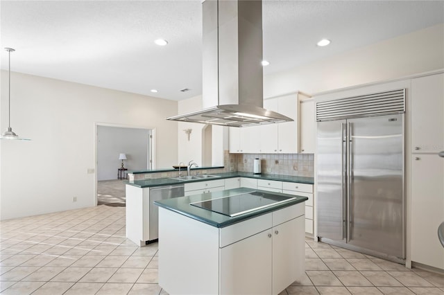 kitchen featuring kitchen peninsula, extractor fan, decorative light fixtures, white cabinets, and appliances with stainless steel finishes