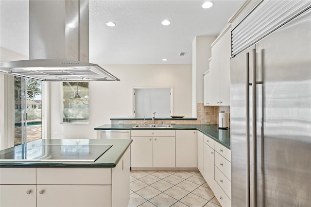 kitchen featuring decorative backsplash, appliances with stainless steel finishes, island range hood, sink, and white cabinets